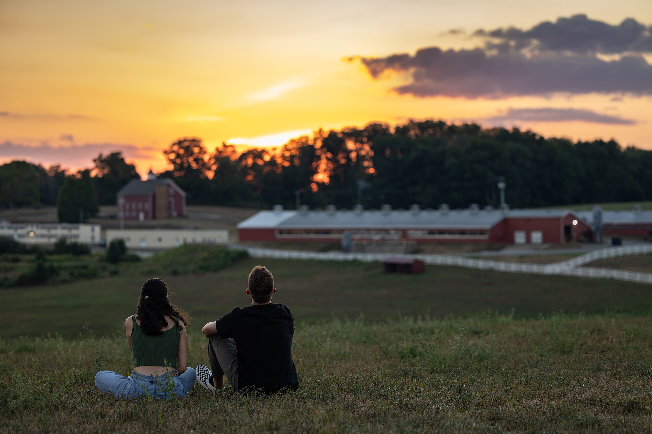 two students watching sunset on horsebarn hill