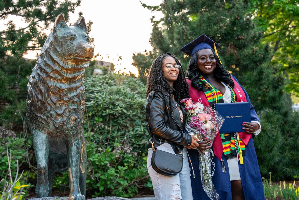 graduate and family in front of Jonathan statue