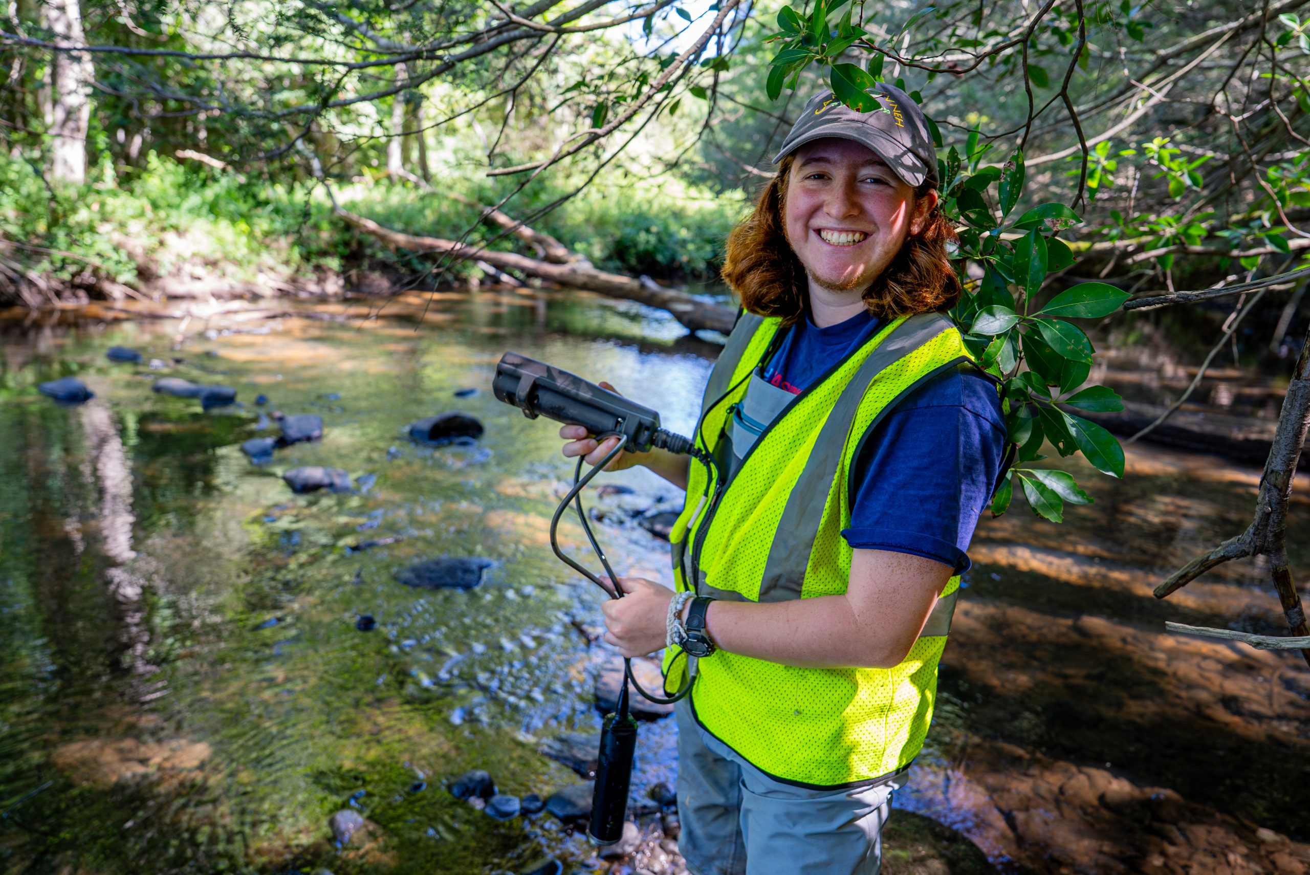 student researcher next to a river