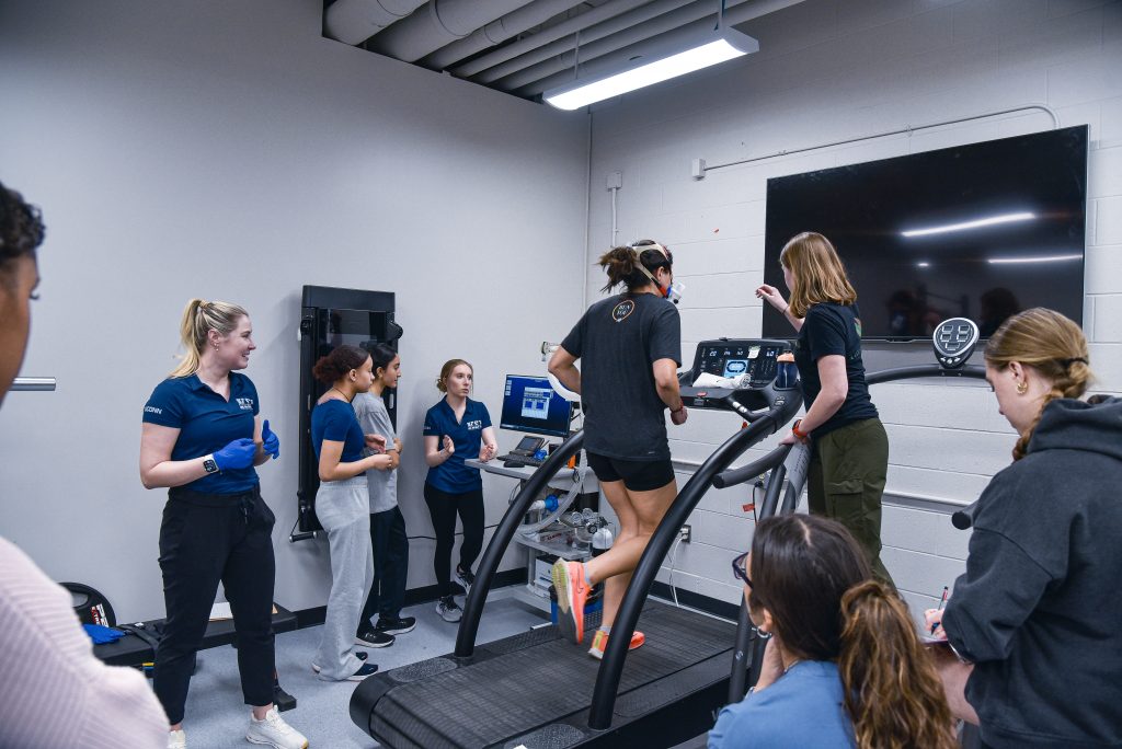 students gathered around a treadmill