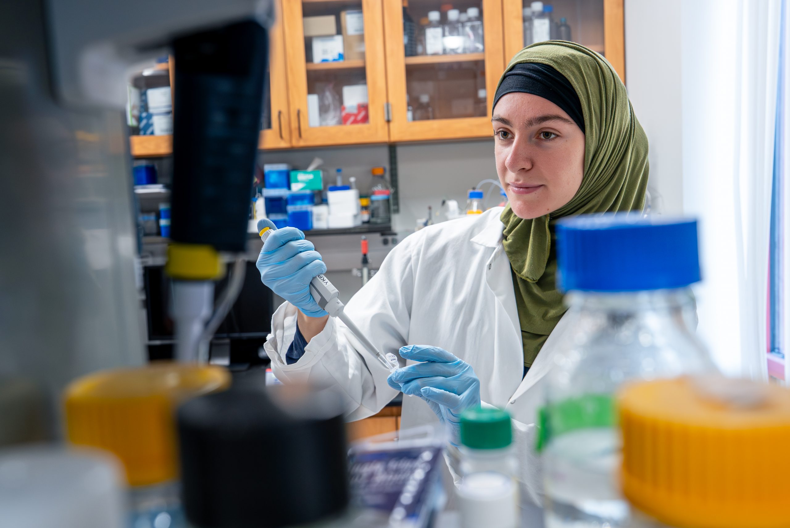 student using a pipette in a lab